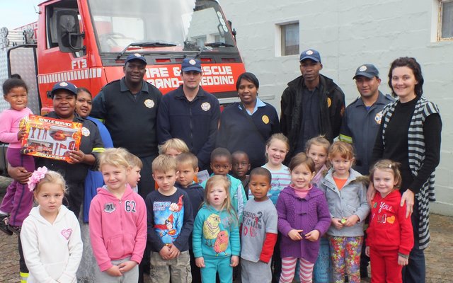 Links agter ontvang Johanay Michau (4) van  Cool Kids Kleuterskool haar Brandweerprys van Cynthia Desemela